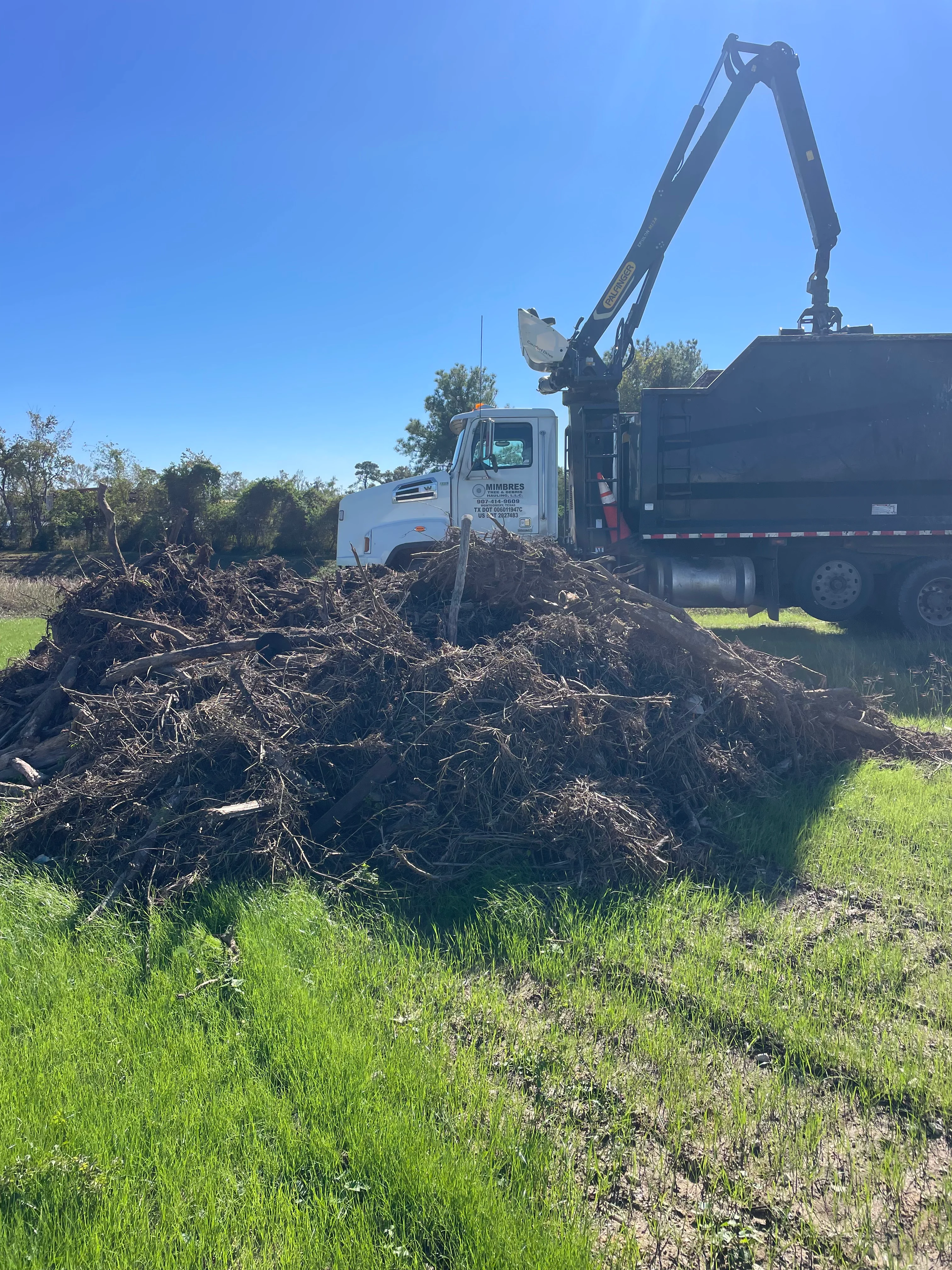 Heavy equipment clearing debris from a Montgomery property during professional site cleanup
